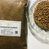 Hand sprinkling fine coriander powder into a simmering pot of curry or a bowl of food.