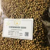 Whole coriander seeds being lightly toasted in a hot pan, emphasizing aroma release.