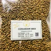 Close-up of light brown, round whole coriander seeds, showing their ribbed texture and consistent size.