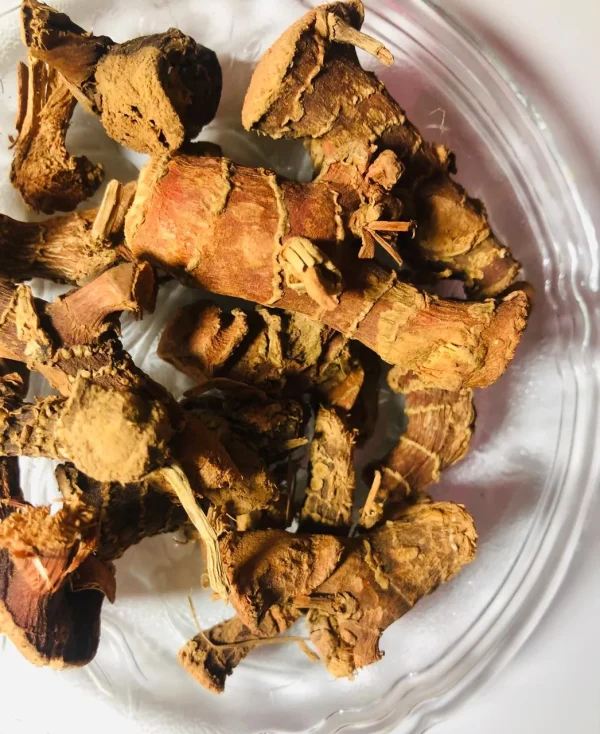 Close-up of dried, pale brown Araththa Root (Alpinia Calcarata) pieces, showing their fibrous texture and aromatic surface.