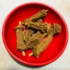 Dried Iramusu pieces steeping in cold or warm water in a clear glass pitcher or traditional clay pot, preparing a refreshing herbal drink.