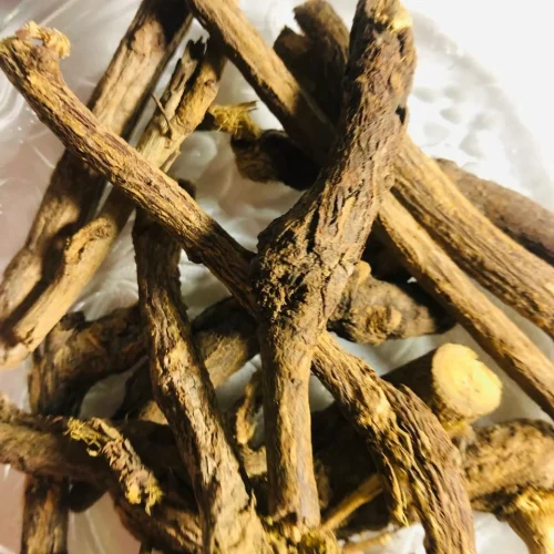 Close-up of dried, fibrous Walmee (Licorice) root pieces or shavings, showing their characteristic light brown exterior and yellowish interior.