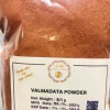 Welmadata Manjishta Powder being mixed with water or rosewater to form a paste for a facial mask, or stirred into a glass of warm water.