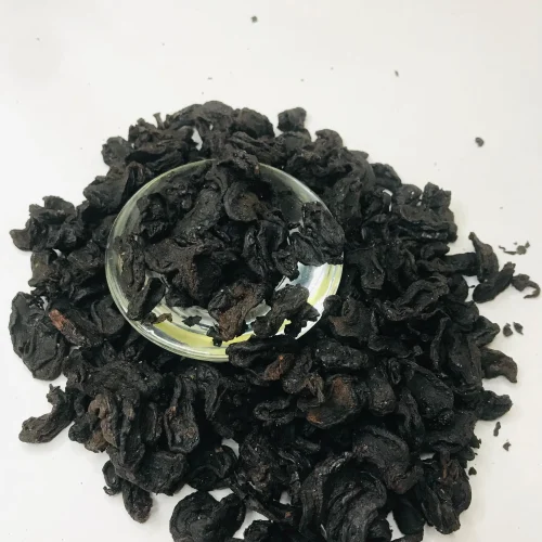 Close-up of dark, dried Garcinia Cambogia rind pieces, showing their texture and readiness for use.